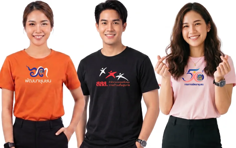 นายแบบและนางแบบสามคนสวมเสื้อยืดพิมพ์ลายโลโก้หน่วยงานและองค์กรภาครัฐจากร้านสกรีนเสื้อ โดยคนซ้ายสุดสวมเสื้อยืดสีส้มอิฐสกรีนโลโก้และข้อความ "พัฒนาชุมชน" คนกลางสวมเสื้อยืดสีดำสกรีนโลโก้คนสามสีและข้อความ "สสส. สำนักงานกองทุนสนับสนุนการสร้างเสริมสุขภาพ" และคนขวาสุดสวมเสื้อยืดสีชมพูอ่อนทำท่ามินิฮาร์ทสกรีนโลโก้ "50 ปี กรมการพัฒนาชุมชน" แสดงถึงผลงานรับสกรีนเสื้อยืดสำหรับหน่วยงานราชการและองค์กรต่างๆ บนพื้นหลังสีขาว